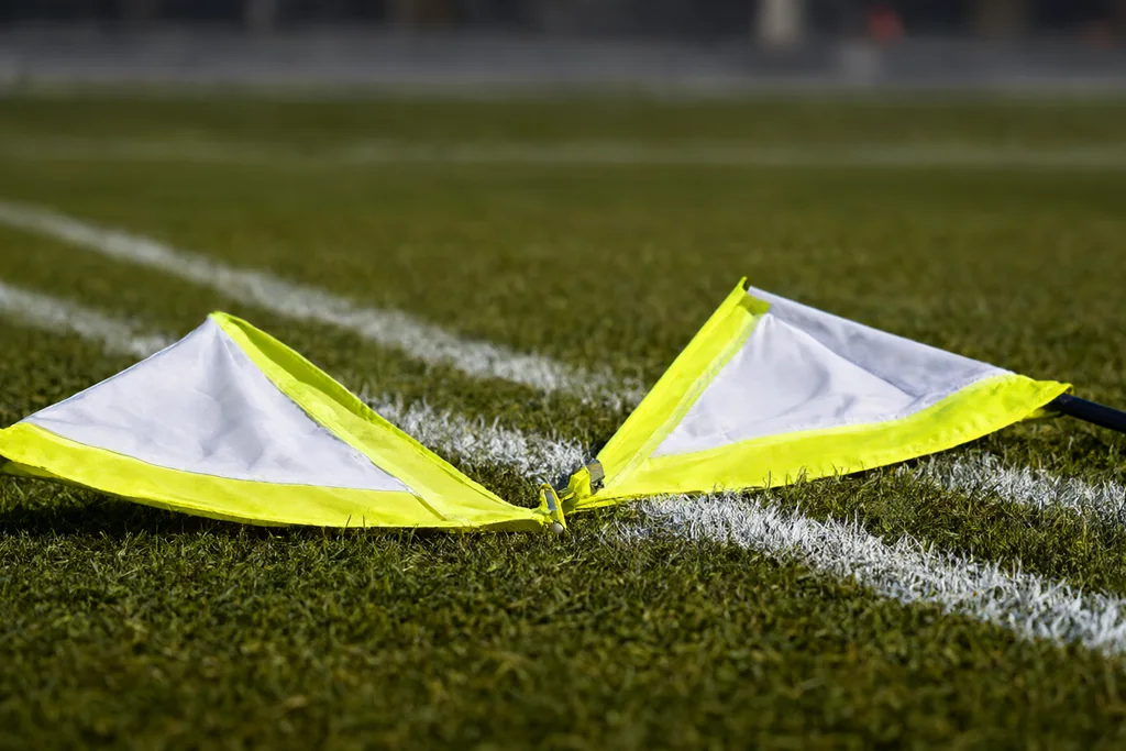 Banderines de árbitro asistente sobre la hierba junto a la línea de banda